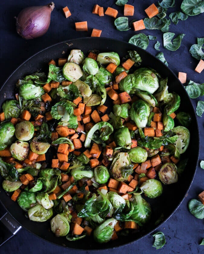 Pan-roasting brussels sprouts and sweet potatoes.