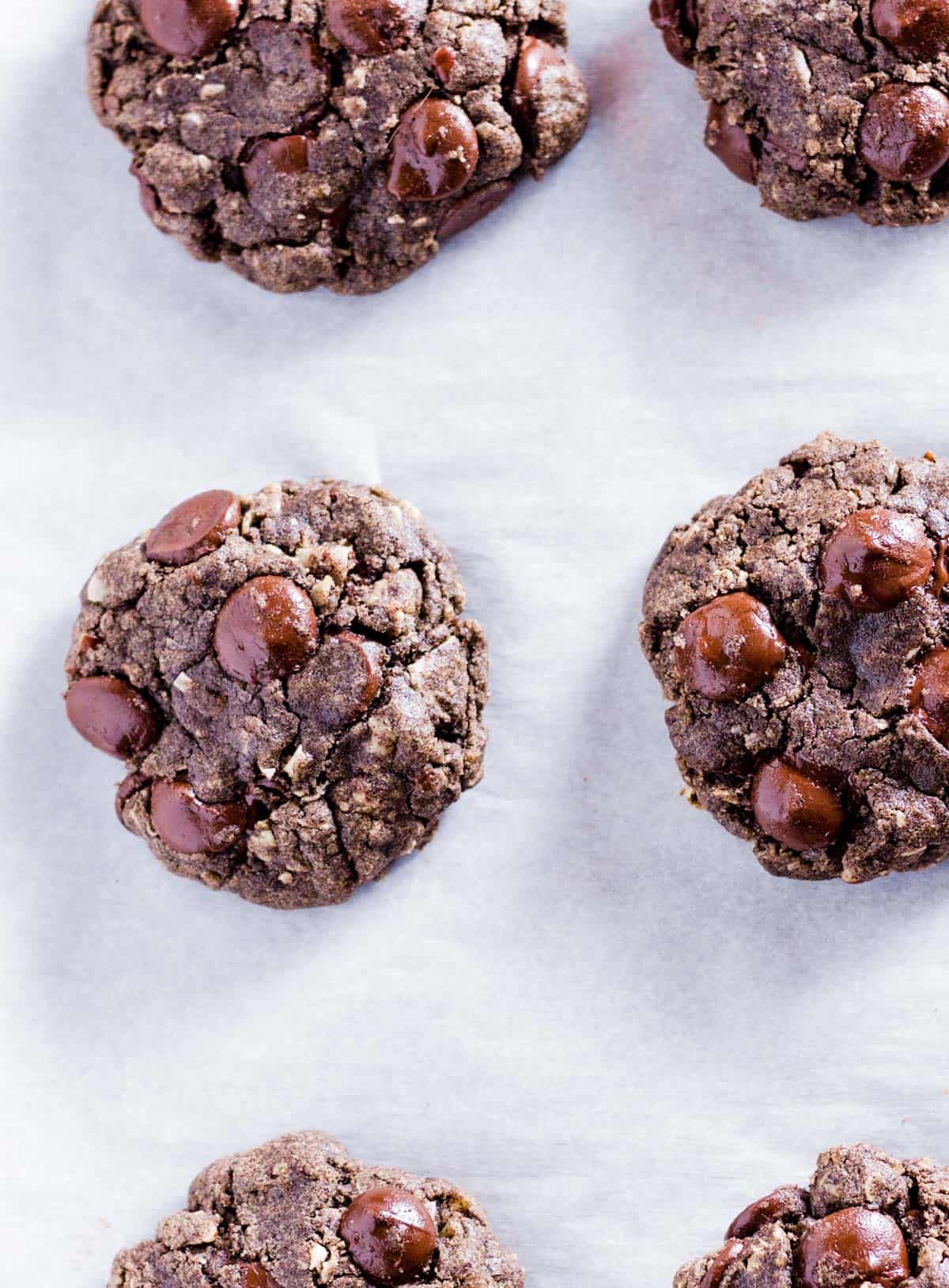 Cookies spaced out on a piece of parchment paper.