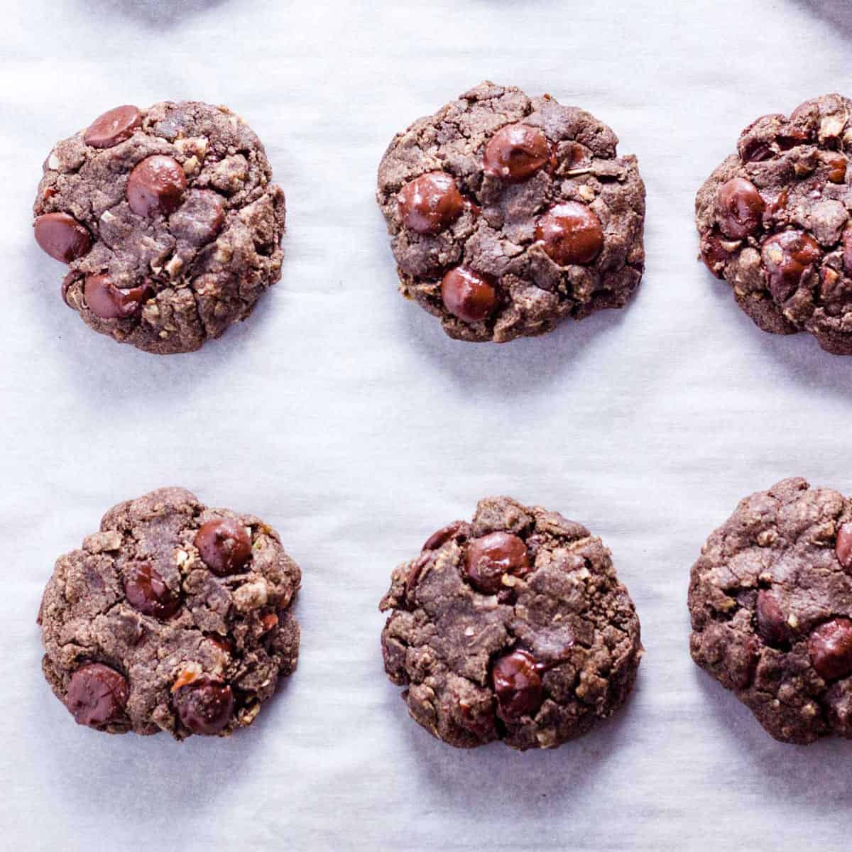 Cookies spaced out on a piece of parchment paper.