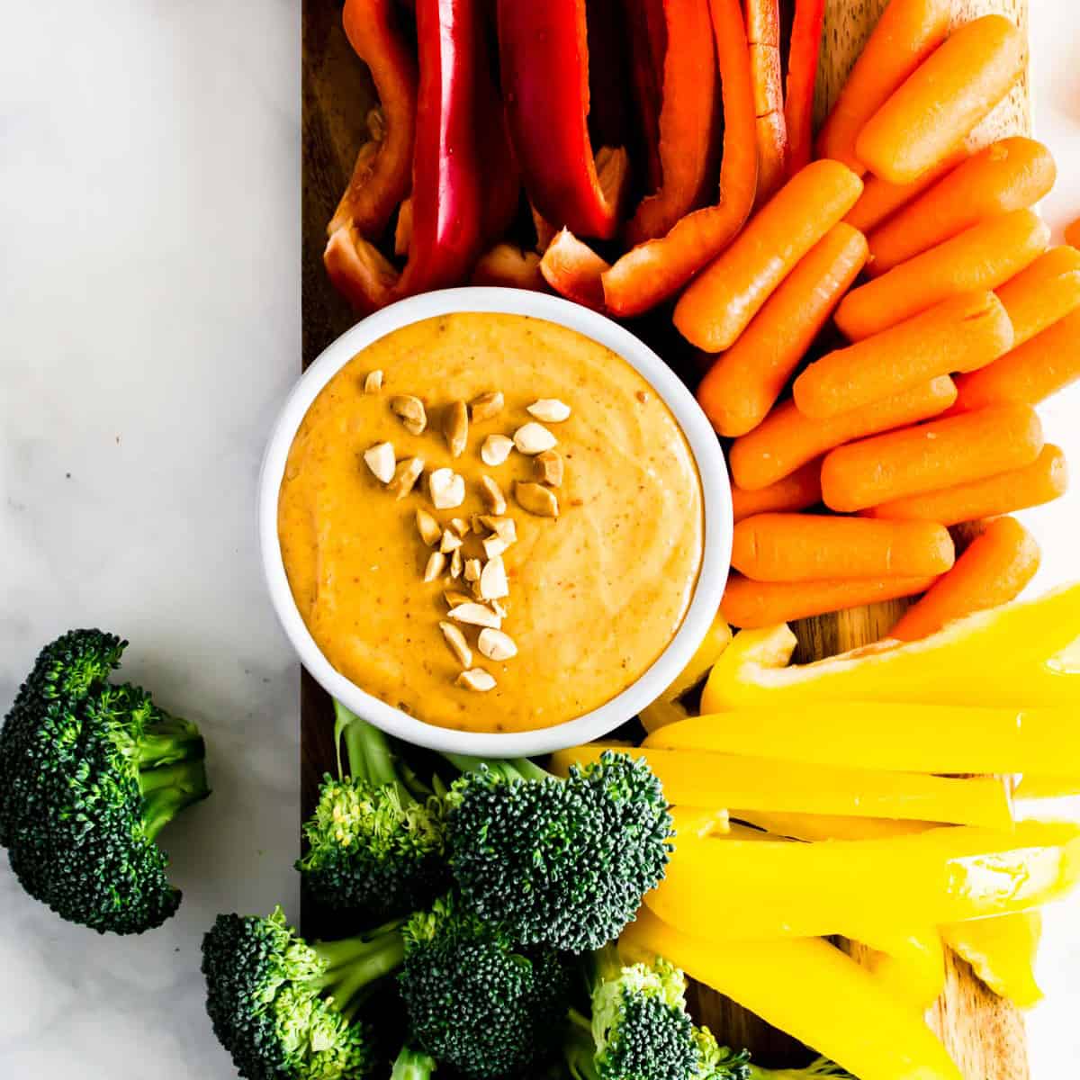 A dish of 5-Minute Peanut Sauce surrounded by a rainbow of veggies.
