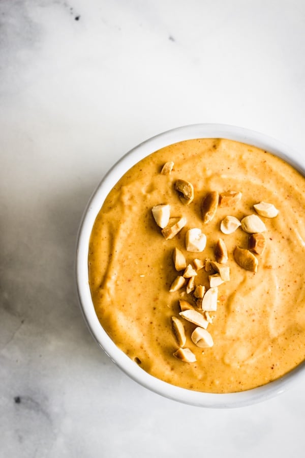 A white dish filled with 5-Minute Peanut Sauce and topped with chopped peanuts.