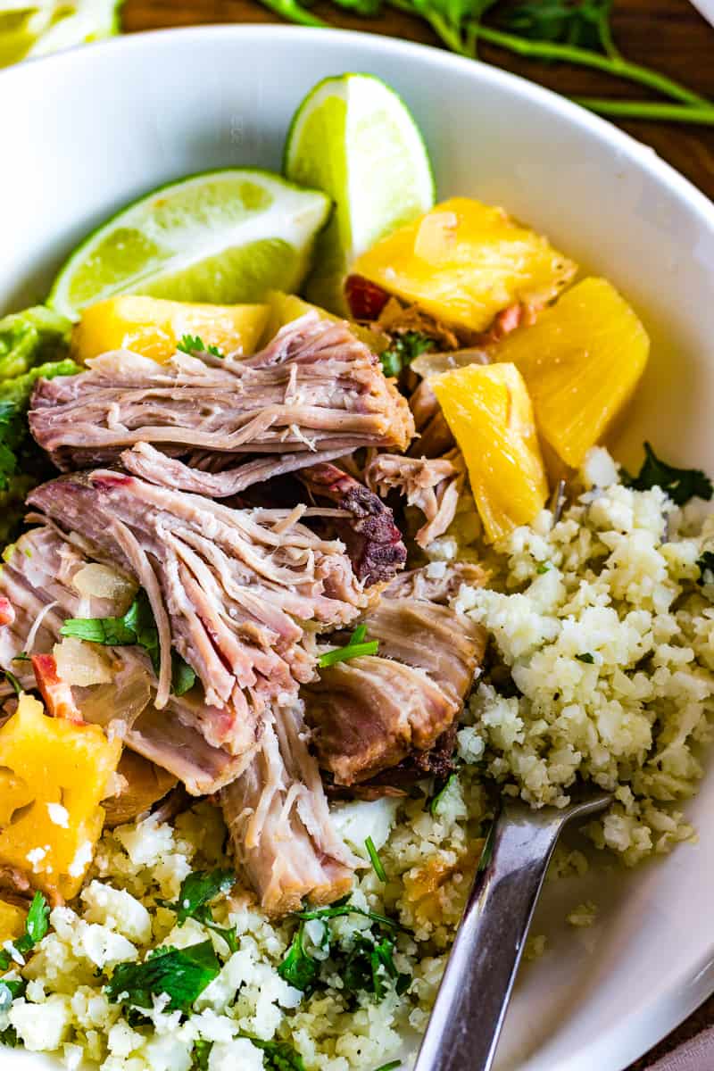 Tender pulled pork is served cilantro cauliflower rice.