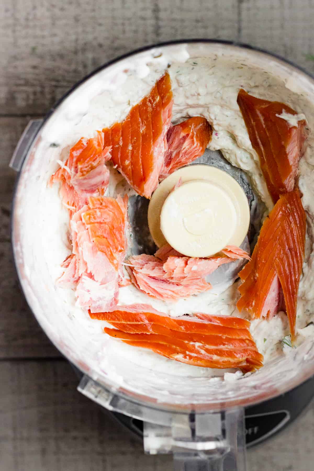 Smoked salmon is added to cream cheese, sour cream, red onion, capers, fresh dill, and fresh lemon juice in a food processor.