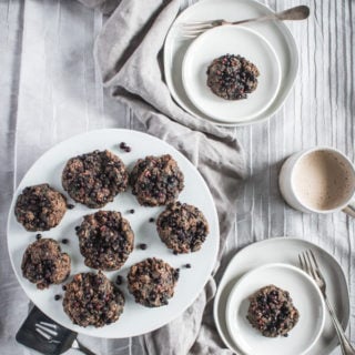 A large plate of superfood morning scuffins. Two smaller plates with a scuffin each and a mug with a hot morning beverage nearby.