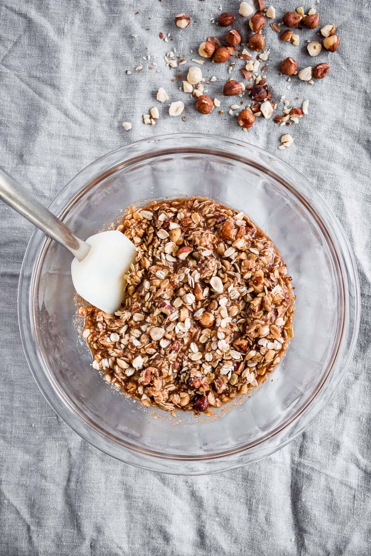 Ingredients for a hazelnut crisp topping are combined in a glass mixing bowl.