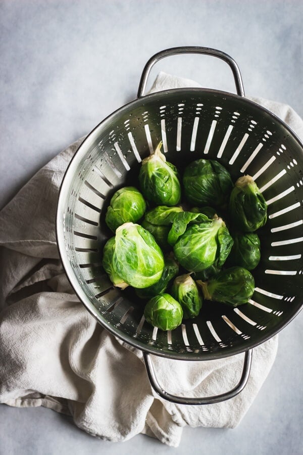 Brussels sprouts rinsed and resting in a colander.