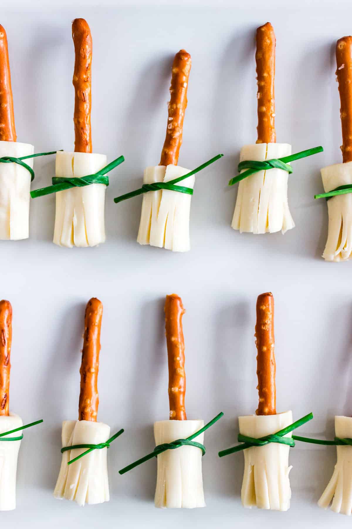 Little broomsticks made with pretzel sticks, string cheese, and chives.