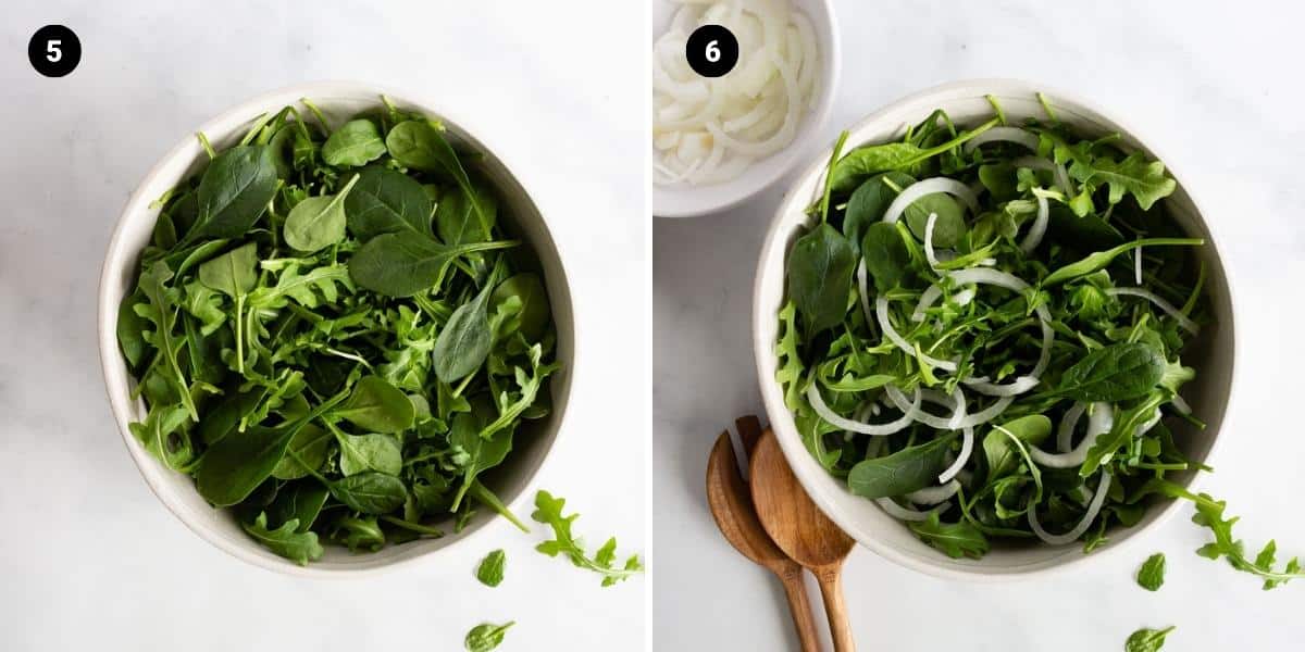 Arugula and spinach are tossed in a bowl and topped with sliced onions.