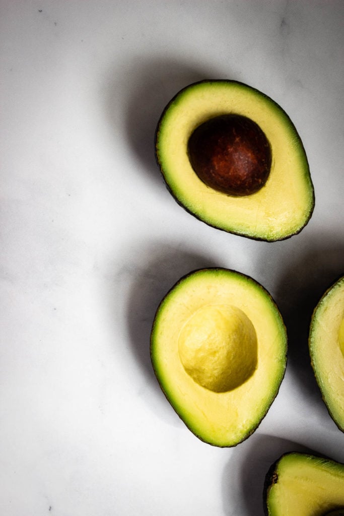 Large Hass avocados cut in half.
