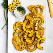Slices of roasted delicata squash served on a white platter.