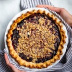 Two hands holding a Gluten-Free Blackberry Bourbon Pie