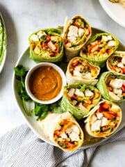 A plate of Thai chicken wraps are served with peanut sauce.
