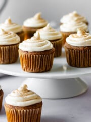 Gluten-free pumpkin cupcakes topped with a piped swirl of cinnamon cream cheese frosting.