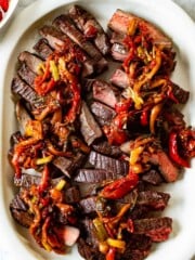 A flank steak is perfectly cooked, sliced into thin strips, and topped with peperonata.