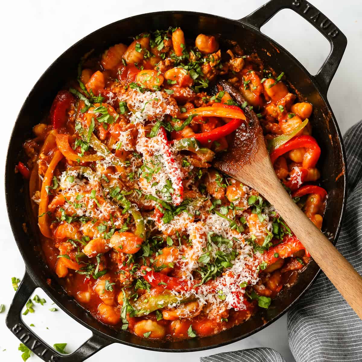 A skillet of gnocchi marinara with sausage and bell peppers.