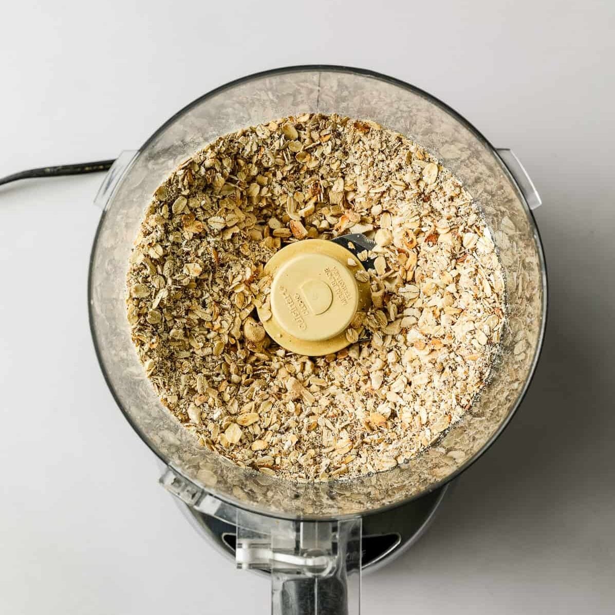 Oats and cashews are pulsed in a food processor.