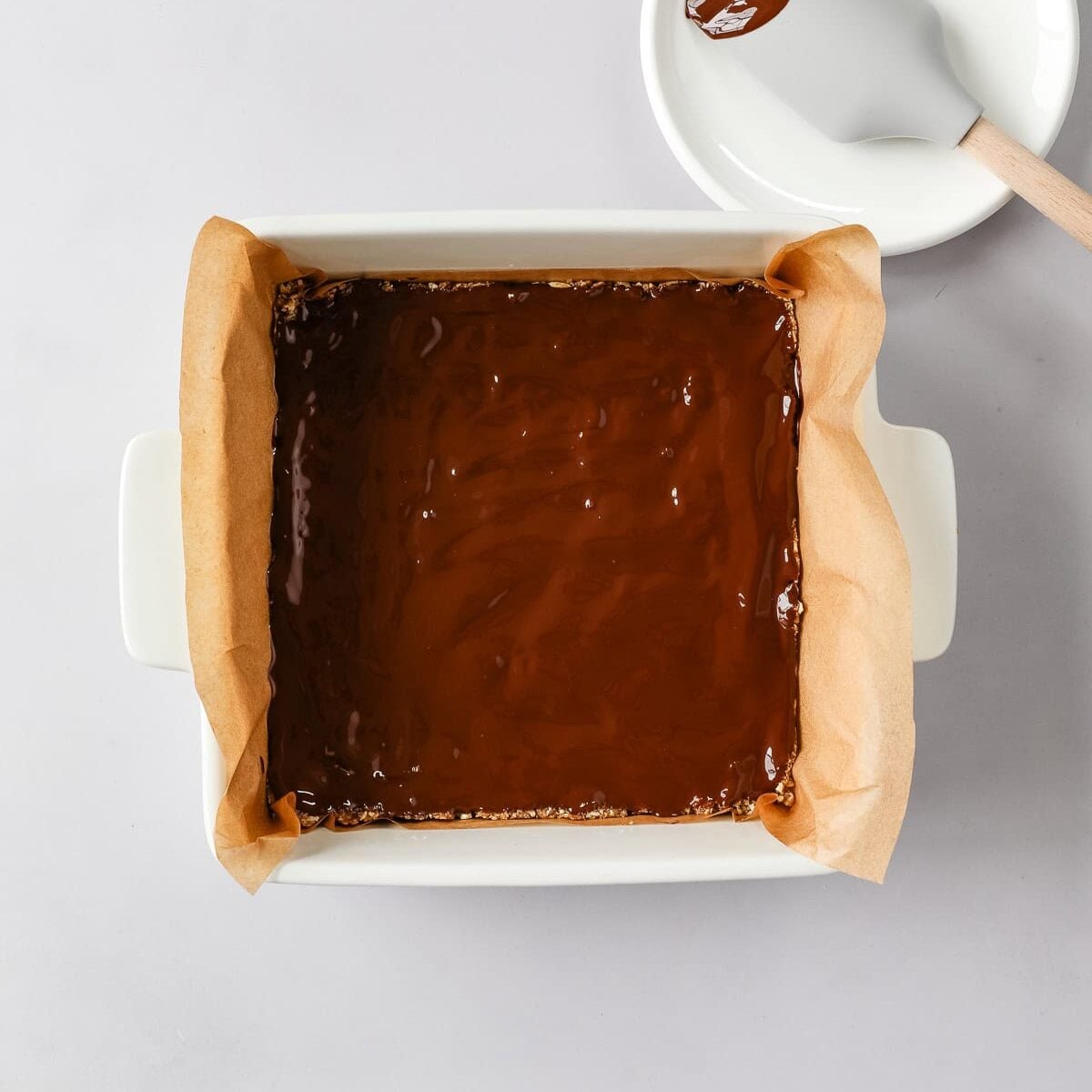 Melted chocolate is spread over the bar base.