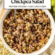 Cranberry pecan chickpea salad in a bowl served with crackers and grapes.