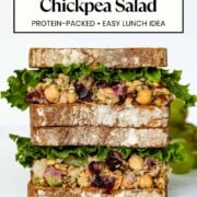Cranberry pecan chickpea salad is served on a sandwich with green lettuce.